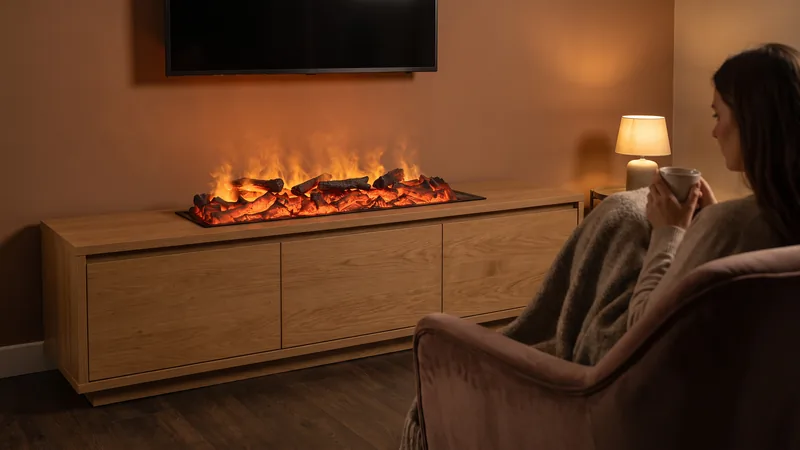 Lo que gasta una chimenea de vapor de agua en una noche: una Rustic Orange 100 encendida en un mueble de roble y una mujer con una taza, tapada con una manta