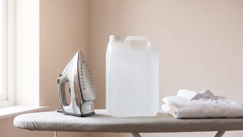 Agua desmineralizada, la misma de la plancha: una garrafa de cinco litros junto a una plancha de vapor y una camisa doblada